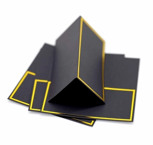 Macro view of black place cards with elegant gold foil borders for weddings and events