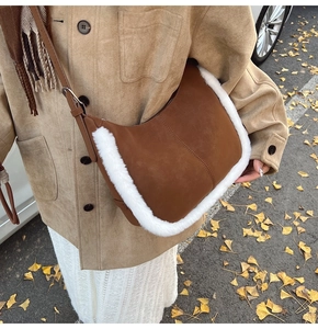 Detail of suede crossbody bag with faux fur trim against a backdrop of autumn leaves