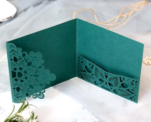 Detailed laser-cut mandala pattern on dark green invitation card with card pocket