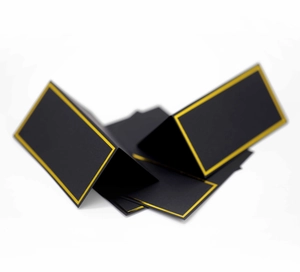 Detail of black folding place cards with elegant gold foil borders for weddings