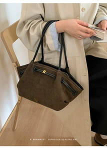 Close-up of brown suede tote bag featuring side strap detail and golden metal hardware