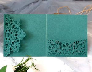 Macro detail of laser-cut floral patterns on premium emerald green cardstock invitations