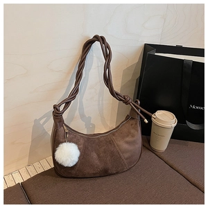 Détail du sac hobo marron foncé avec daim et bandoulière tressée en cuir