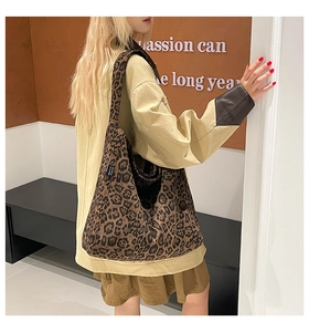 Detailed macro view of retro leopard print canvas shoulder bag with woven side label
