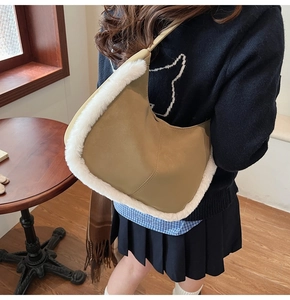 Detail of khaki leather shoulder bag featuring white faux fur trim and sleek edges