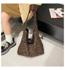 Detail of leopard print hobo bag showing fabric texture and side brand woven label
