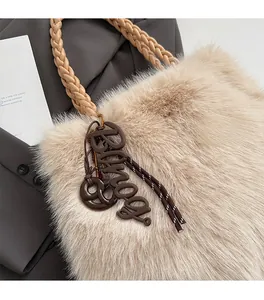 Detail of beige faux fur tote bag with brown woven PU handle and stylish letter charm