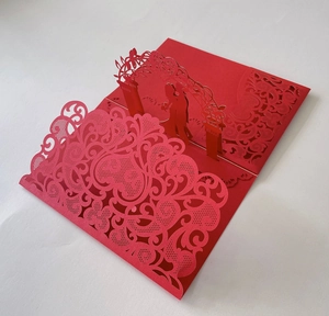 Macro shot of 3D laser cut wedding card with bride and groom under a floral arch