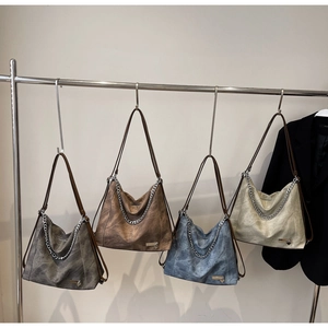 Detailed display of four large vintage shoulder bags in various colors with metal chains
