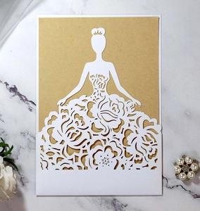 Detail of laser-cut floral gown design on white invitation card with kraft insert