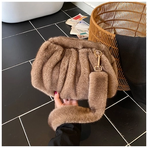Detail of plush cloud bag with brown faux fur texture and golden metal hardware buckle
