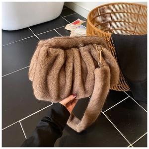 Detail of soft brown faux fur pleat cloud bag with plush strap and gold metal buckle
