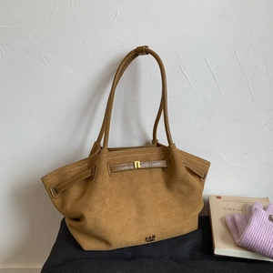 Retro tan suede tote bag with golden buckle and sleek handles on a minimalist background