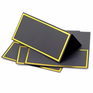 Elegant black place cards with gold foil borders, shown folded and flat on white background