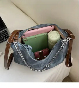 Detailed view of spacious denim tote interior holding tablets and daily essentials