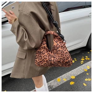Detail of vintage leopard print crescent bag with woven knots and autumn street style