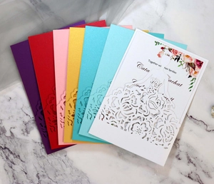 Macro detail of laser-cut bridal invitations in multiple pearlescent colors with elegant patterns