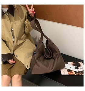 Detail of a large brown suede hobo bag with MALIVI side tag and soft matte texture