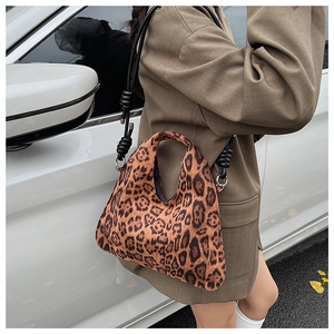 Detailed close-up of leopard print tote bag with thick black knotted shoulder strap
