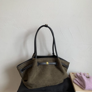 Detail of dark olive suede tote bag with golden hardware and pleated texture detail