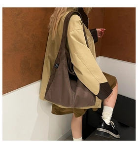 Brown suede tote bag side detail showing high-quality texture and black brand label