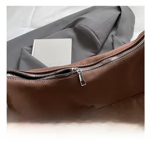 Detail of silver zipper and white stitching on brown vintage shoulder bag exterior