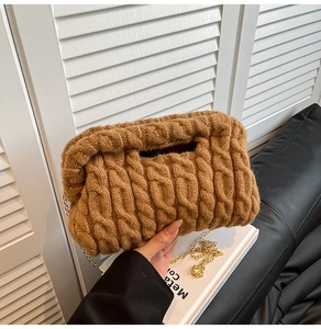 Close-up of caramel chunky knit handbag with a golden chain strap and cable pattern