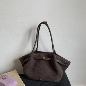 Detailed close-up of dark brown suede tote bag with golden hardware and textured surface