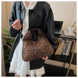 Detailed close-up of a leopard print hobo bag with animal pattern in an office setting
