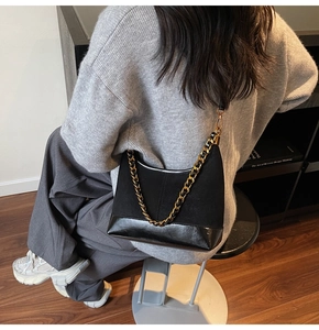 Detail of vintage black patchwork shoulder bag with chunky gold chain decoration