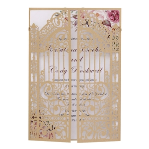 Detail of laser-cut gold gate wedding invitation with floral insert on white background