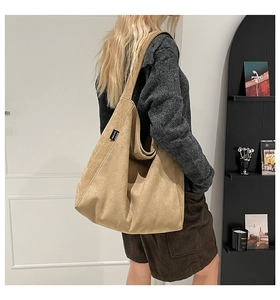 Detail of khaki corduroy tote bag showing soft ribbed texture and side brand label tag