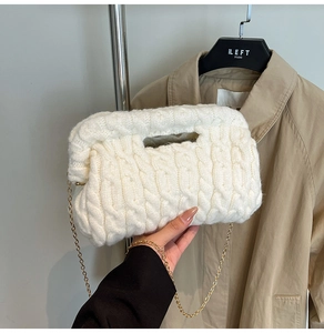 Close-up of white cable knit texture and gold chain on chunky knit cloud handbag