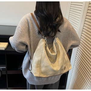 Detail of vintage beige convertible tote with soft matte leather and silver chain