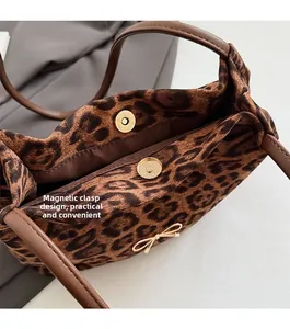 Dettaglio della borsa leopardata con fibbia magnetica e fiocco dorato decorativo