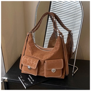 Detailed close-up of brown suede hobo bag with leopard print texture and twin utility pockets