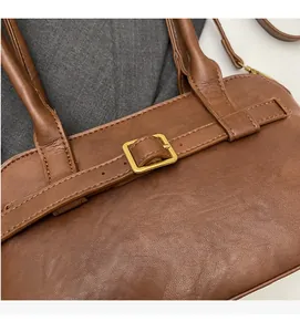 Detailed close-up of dark brown PU leather texture and gold buckle on stylish shoulder bag