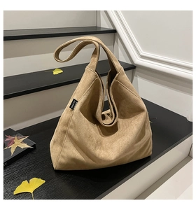Detail of soft khaki suede tote bag texture with minimalist side woven brand label