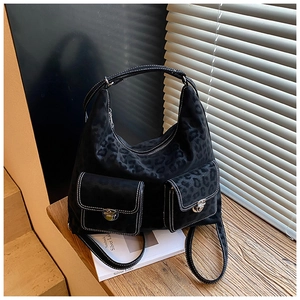 Detail of black leopard print hobo bag showing contrast stitching and silver snap pockets