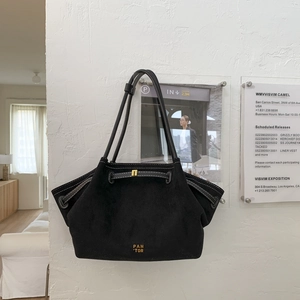 Detail of black suede tote bag featuring pleated texture and golden metal buckle