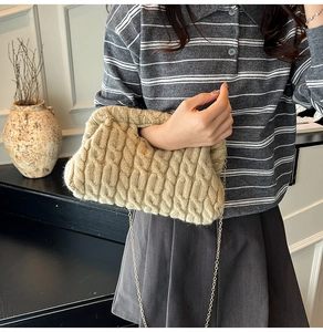 Detail of beige cable-knit crossbody bag with elegant gold chain strap for women