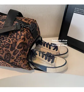 Sac fourre-tout léopard montrant un compartiment à chaussures latéral avec baskets