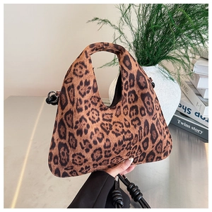 Detail of leopard print faux suede tote bag with black twisted shoulder strap and cutout handle