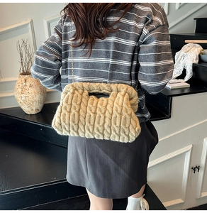 Detail of beige knit chain bag featuring thick cable weave and golden strap on model