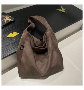 Detail showing the brown suede fabric texture and MALIVI woven label on the tote bag