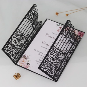 Detail of laser-cut gate design on dark green wedding invitation with floral inner card