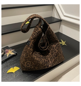 Detail of large tote bag in leopard print with woven MALIVI brand tag on the side