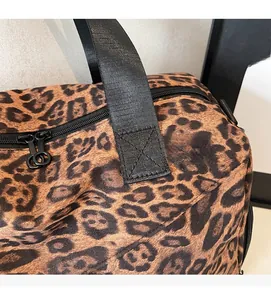 Gros plan sur le motif léopard et les sangles en nylon renforcées du sac fourre-tout
