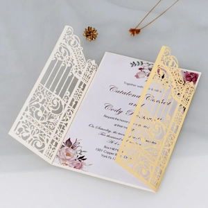 Detailed laser-cut vine patterns on pale pink and ivory wedding invitation card set