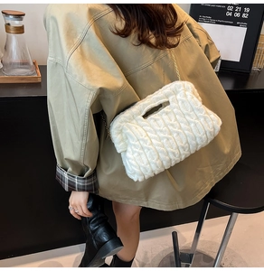 Detail of white chunky knit crossbody bag with golden chain strap on a model
